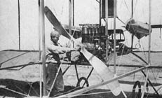 John Halleck, Curtiss' chief mechanic, adjusts a mahogany propeller. .